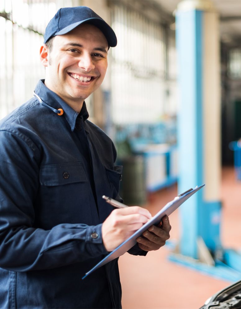 Happy technician ticking off a service sheet - MOT Testing Havant