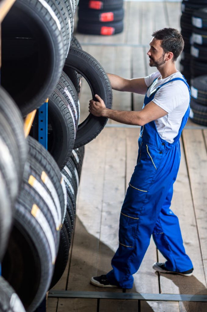 Mechanic pulling out a tyre from stock - Tyres Havant